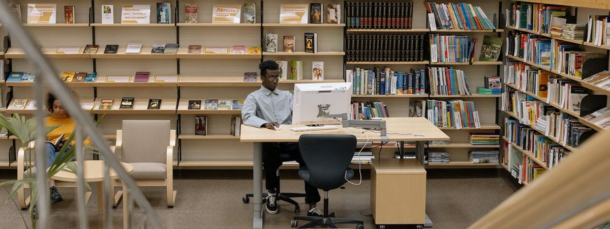 Man sitting at a desktop computer in public library.
