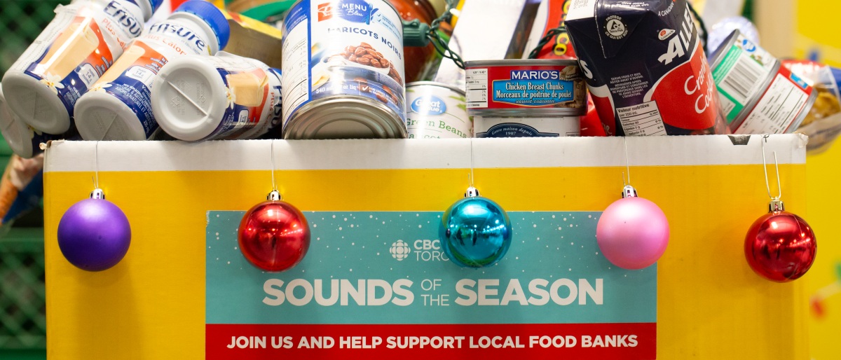 yellow food donation bin with Christmas baubles and donated nonperishables