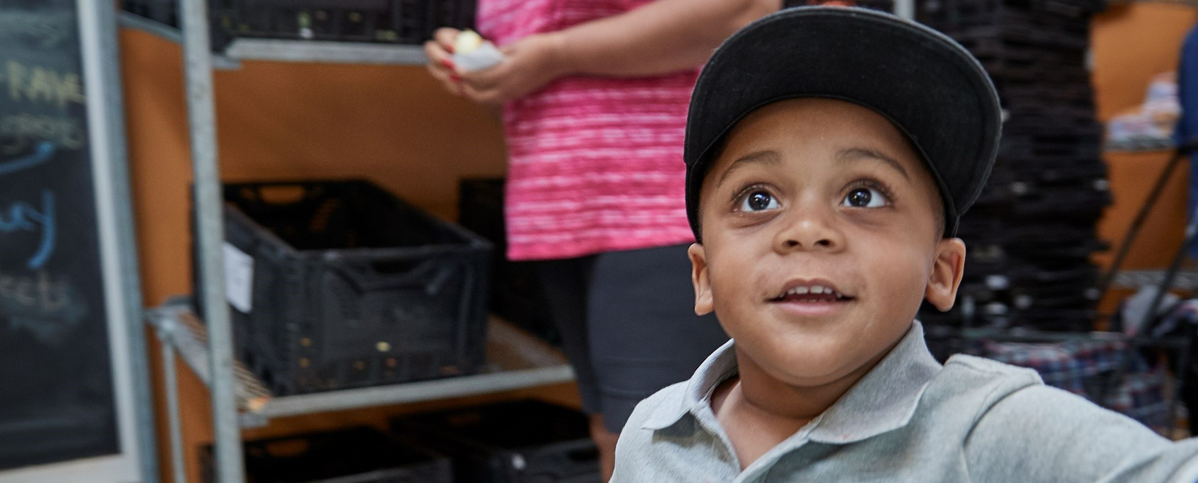 Boy with black baseball cap looking up in wonder